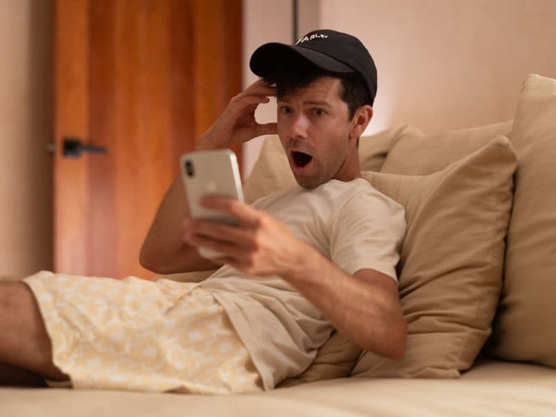 A person viewing a smartphone while relaxing on a sofa
