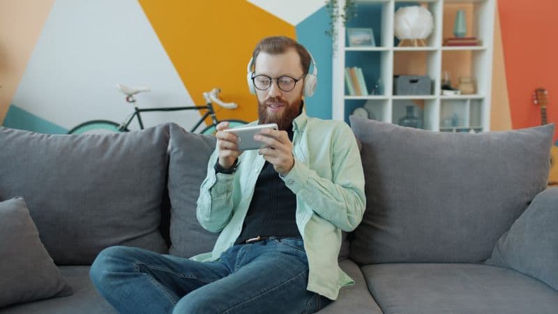 A person watching media on a phone with headphones